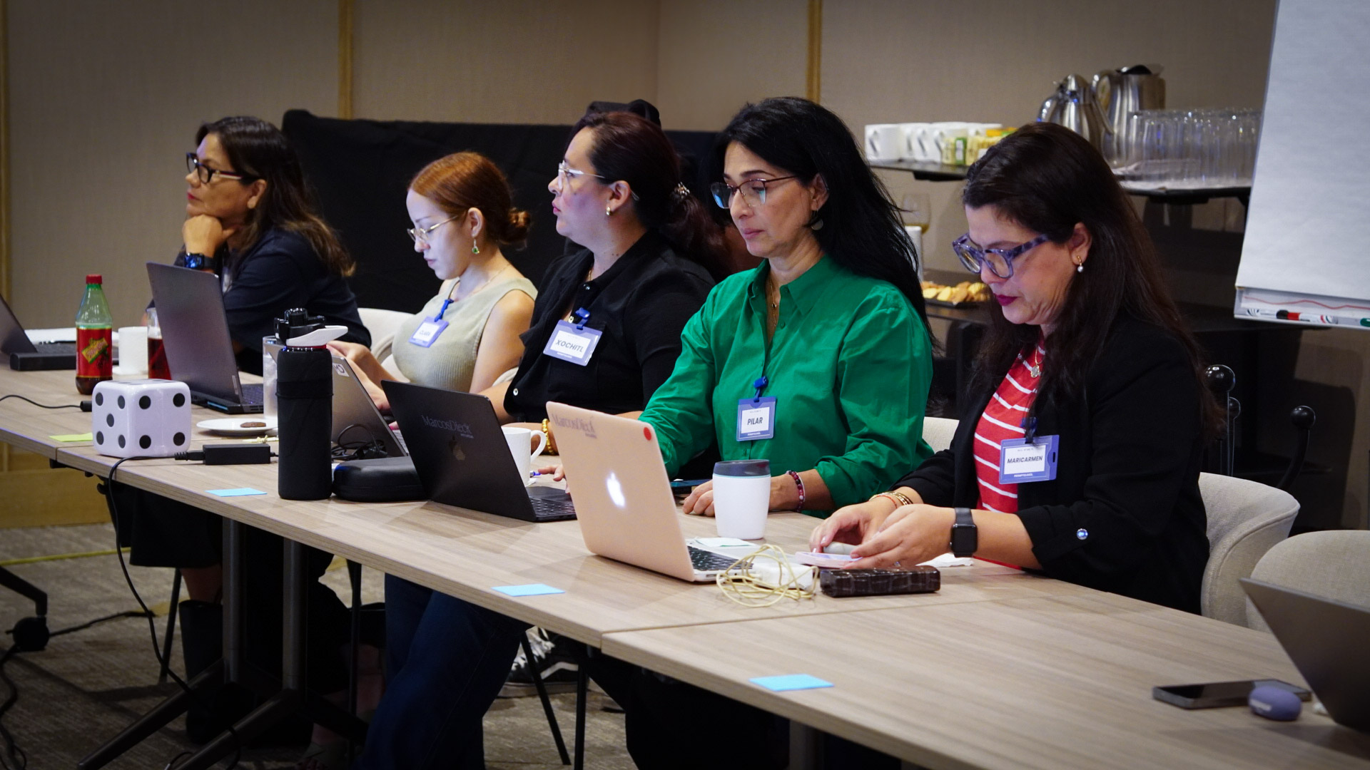 Participantes trabajando con sus computadoras durante Promptología